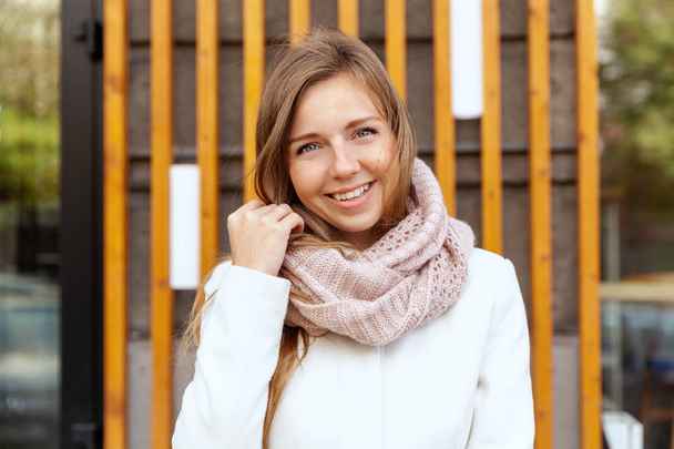 Happy smiling young woman in white coat opposite the office looking at camera - Fotoğraf, Görsel