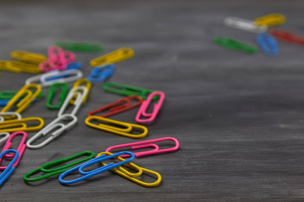 Multicolored paper clips on a dark background - Фото, изображение