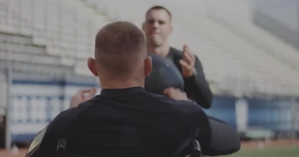 Wheelvoorgezeten atleet en trainer gooien geneeskunde bal - Video