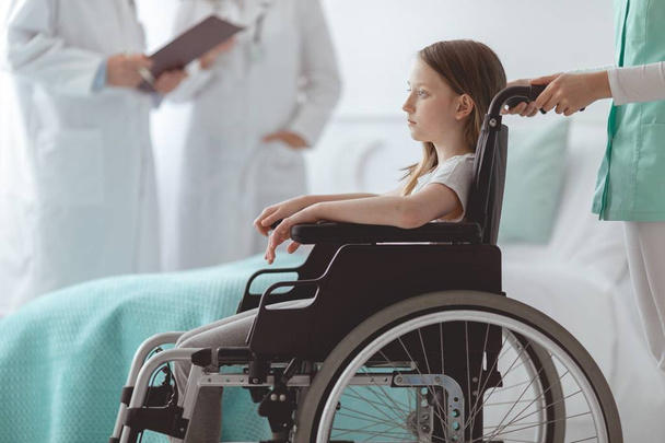 Afraid child on the wheelchair in the hospital - Valokuva, kuva
