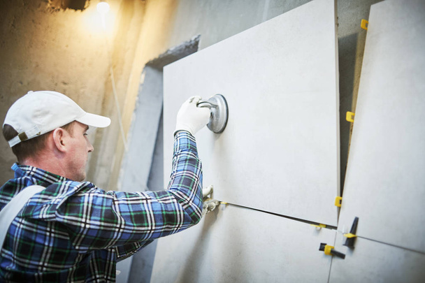 tiler instalación de azulejos de gran formato en la pared. casa interior renovación
 - Foto, imagen