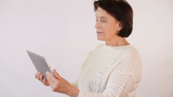 Elderly woman talking via skype - Materiał filmowy, wideo