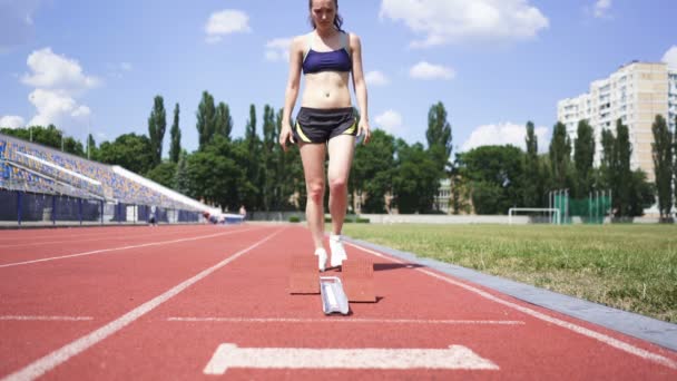 Giovane ragazza bruna atleta in grado di iniziare a correre sullo stadio. Vista in avanti
 - Filmati, video