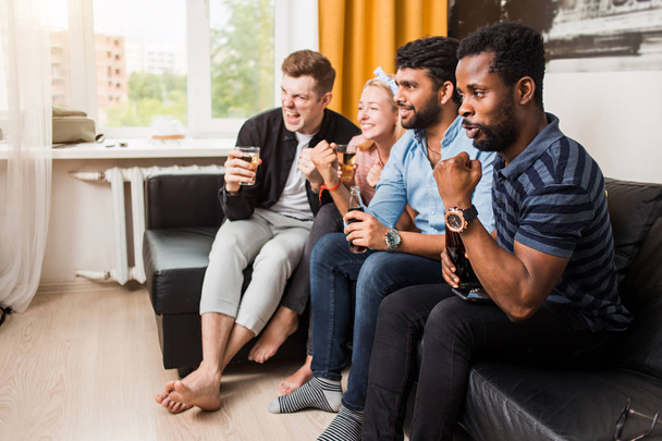 Group of friends watching television at home together - Foto, Imagen