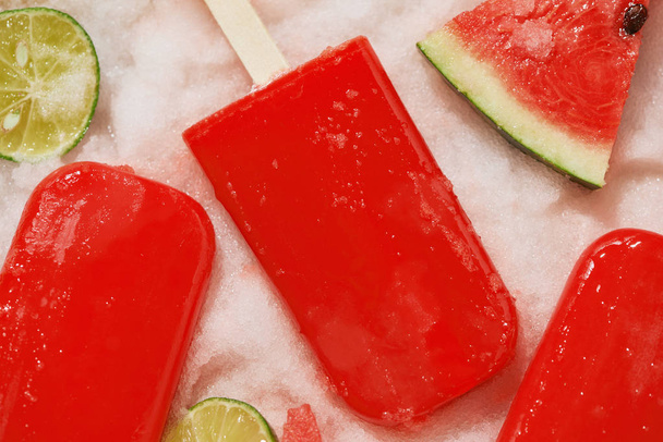 Watermelon popsicles and sliced lemon on ice filled tray  - Photo, Image