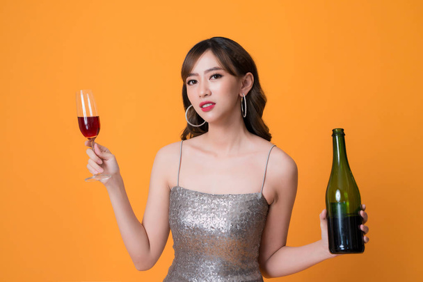 Великолепная праздничная молодая азиатка выпивает бокал вина
. - Фото, изображение