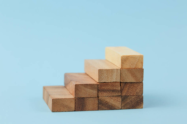 Stairs of wooden blocks on blue background. - Photo, Image