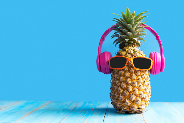 Summer in the party.  Hipster Pineapple Fashion in sunglass and music bright beautiful color in holiday, Creative art fruit for tropical style on the beach vibes, blue background.  Fashion Summer Vacation Concept - Foto, Imagem