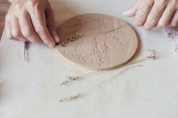 Hands make a round clay product with the words "Family". - Fotó, kép