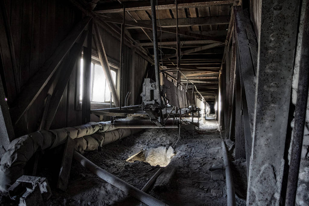 Εγκαταλελειμμένο εργοστάσιο. Παλιά σκονισμένη ταινία μεταφορέα σε παλιό διάδρομο εκ νέου - Φωτογραφία, εικόνα