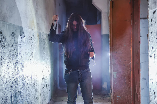 Serial killer maniac with knife in dark abandoned building. Mani - Фото, зображення
