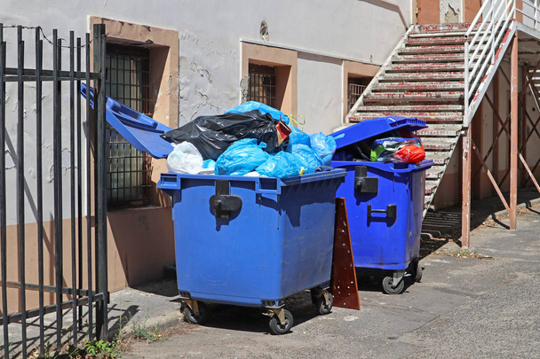 Latas de lixo no quintal de um antigo edifício industrial
 - Foto, Imagem