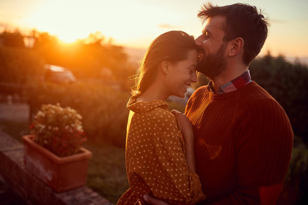 homem romântico e mulher beijando ao pôr do sol
 - Foto, Imagem