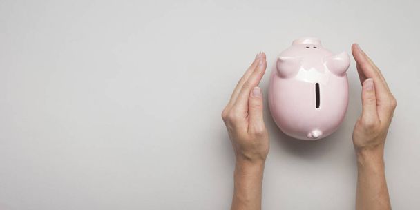 woman hand putting money coin into piggy for saving money wealth and financial concept. - Fotó, kép