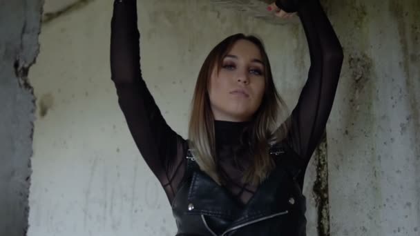 Brutal girl in an abandoned building. Model in black leather clothes - Záběry, video