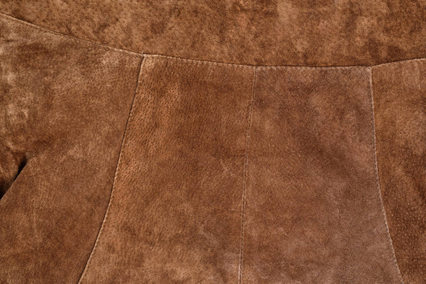 Часть коричневой текстурной замшевой одежды. Настоящая кожа
 - Фото, изображение