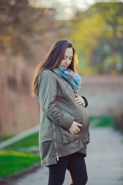 Zwangere vrouw stokken achter de buik - Foto, afbeelding