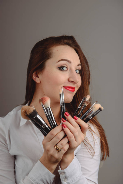 Nő, kezében egy sor kozmetikai kefék a make-up, - Fotó, kép
