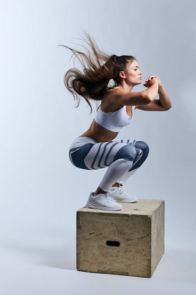 pleasant active ambitious sportswoman doing squats - Photo, Image