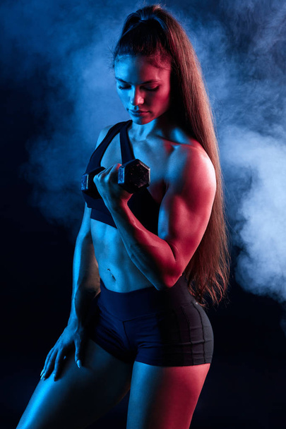 strong muscular woman training with dumbbell - Foto, afbeelding