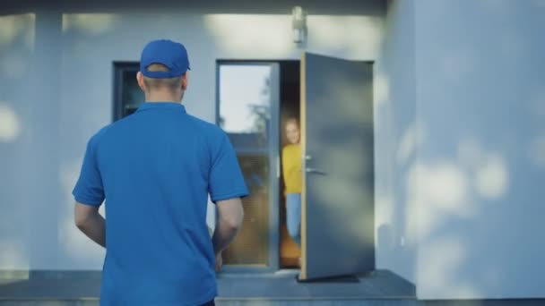 Beautiful Young Woman Opens Doors of Her House and Meets Delivery Man who Gives Her Cardboard Box Package, She Signs Electronic Signature POD Device. - Materiał filmowy, wideo