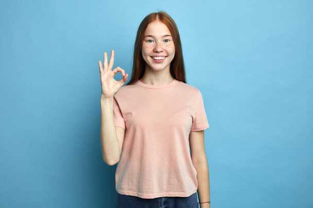 positive female student with freckles showing ok sign with fingers - Fotoğraf, Görsel