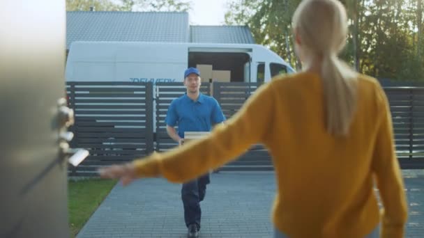 Beautiful Young Woman Opens Doors of Her House and Meets Delivery Man who Gives Her Cardboard Box Postal Package, She Signs Electronic Signature POD Device. - Metraje, vídeo