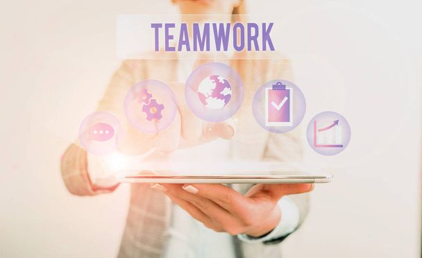 Conceptual hand writing showing Teamwork. Business photo showcasing Group of showing who work together as one and with the same aim Female human wear formal work suit presenting smart device. - Fotografie, Obrázek