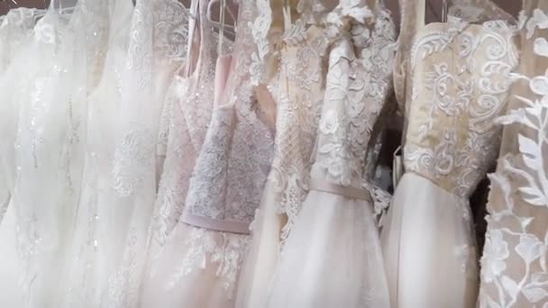 Estante con muchos vestidos de novia hermosos en la tienda
. - Metraje, vídeo