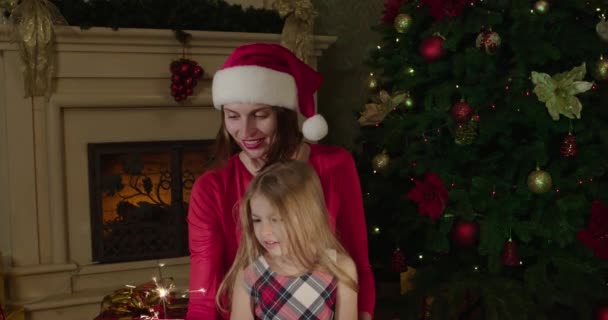 Noel arifesi. Noel ağacı sahnesi. Babygirl ve anne Noel ağacı giyiyor ve sürecin tadını çıkarıyor. - Video, Çekim