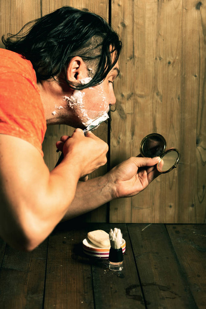 El hombre se afeita con una afeitadora peligrosa
. - Foto, imagen