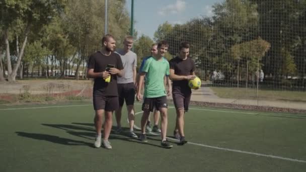 Cheerful soccer players walk into football pitch - Felvétel, videó