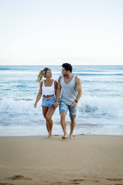 Casual young couple walking at the beach - Foto, afbeelding