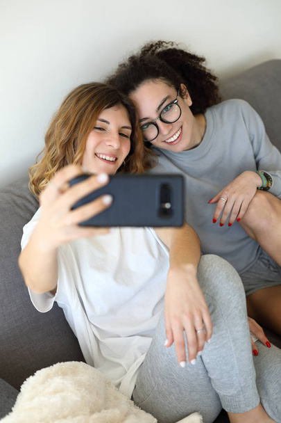 Jong vrouwelijk koppel thuis het nemen van selfie - Foto, afbeelding