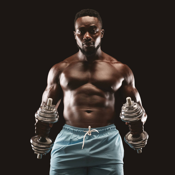 Portrait of afro bodybuilder doing workout with barbells - Foto, afbeelding