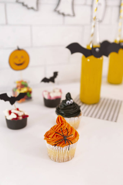 Creative sweet cupcakes and pumpkin juice in glass bottles - Photo, Image