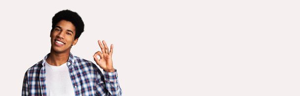 Возбужденный африканский парень жестом ОК знак и улыбка
 - Фото, изображение