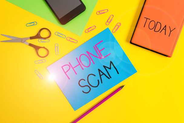 Handwriting text writing Phone Scam. Concept meaning getting unwanted calls to promote products or service Telesales Paper sheets pencil clips smartphone scissors notebook colored background. - Photo, Image