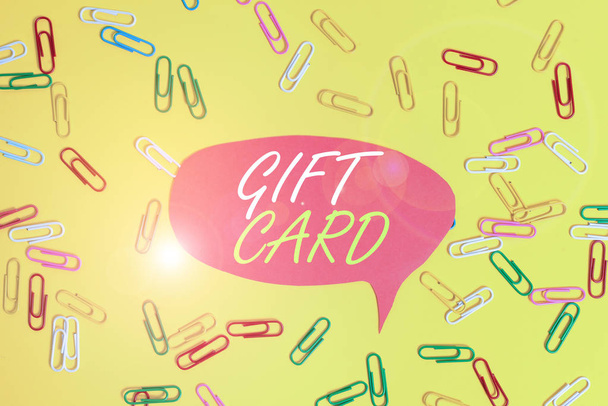Handwriting text Gift Card. Concept meaning A present usually made of paper that contains your message Flat lay above empty paper with copy space and colored paper clips. - Photo, Image