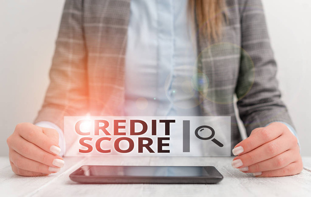 Handwriting text writing Credit Score. Concept meaning creditworthiness of an individual based on credit files Business woman sitting with mobile phone on the table. - Photo, Image