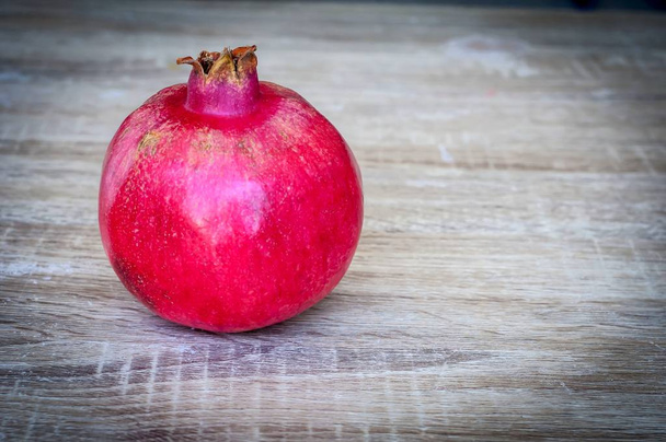 Fresh red pomegranate fruit close up image on a wooden background, Jewish New Year Rosh Hashana concept image. - Фото, изображение