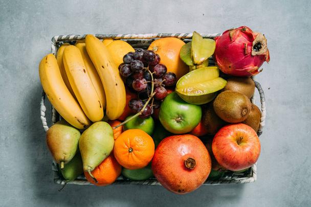 Groot bord met verschillende verse biologische vruchten. Oogst en gezond biologisch voedsel concept - Foto, afbeelding