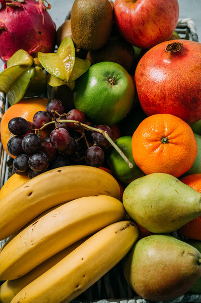 Close-up van een groot bord met verschillende verse biologische vruchten. Oogst en gezond biologisch voedsel concept - Foto, afbeelding