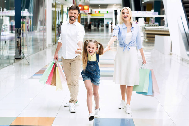 Familie van drie doen winkelen wandelen in het winkelcentrum - Foto, afbeelding