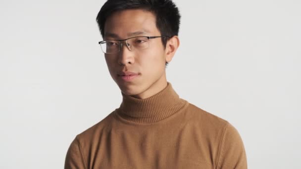 Bonito elegante sorrindo asiático homem em óculos confiantemente olhando na câmera isolado
 - Filmagem, Vídeo