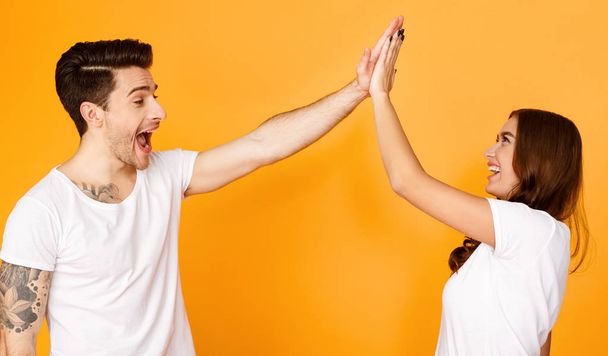 Joyful man and woman greeting each other with high five - Photo, Image