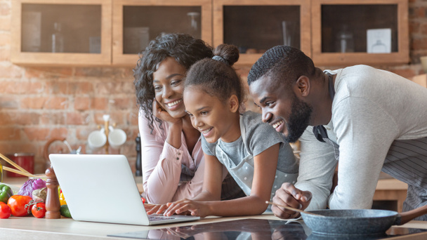 Família alegre usando laptop na cozinha, à procura de receita
 - Foto, Imagem