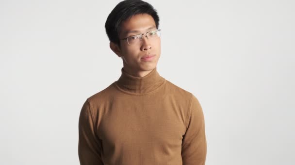 Молодой серьезный азиат в очках уверенно не показывает жеста на камеру изолирован
 - Кадры, видео
