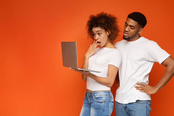 Shocked negro millennial pareja de navegación en el ordenador portátil
 - Foto, Imagen