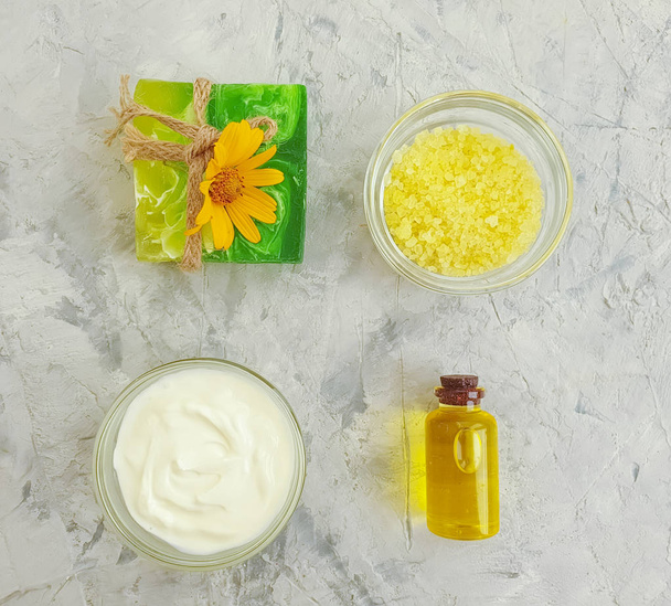 cosmetic cream, calendula flower soap on concrete background - Foto, Bild